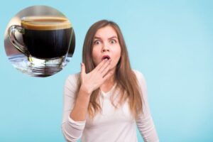 donna scioccata con una mano davanti alla bocca e una tazzina di caffè in un riquadro in alto