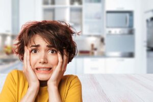 cucina sullo sfondo e donna spaventata in primo piano