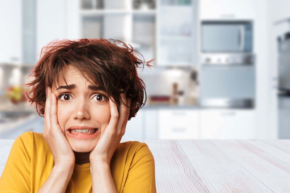 cucina sullo sfondo e donna spaventata in primo piano